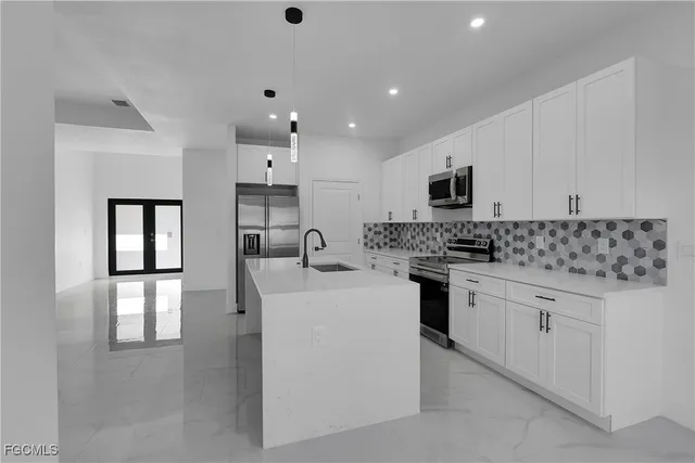 a kitchen with stainless steel appliances granite countertop a sink stove and cabinets
