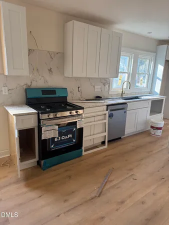 a kitchen with a stove and white cabinets