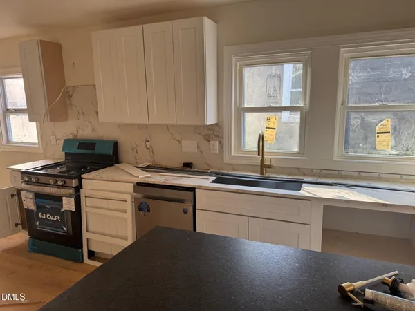 a kitchen with a sink stove and cabinets