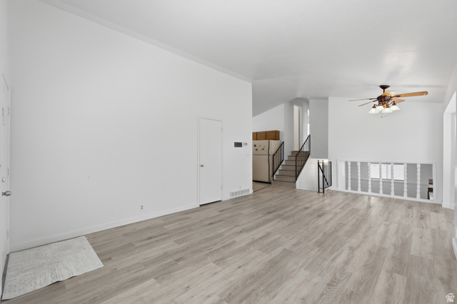 7910 Woolley Way Magna, UT 84044 - Photo 4 of 26 Spacious open room featuring wood-finish flooring, a ceiling fan with integrated lighting, and white baseboards