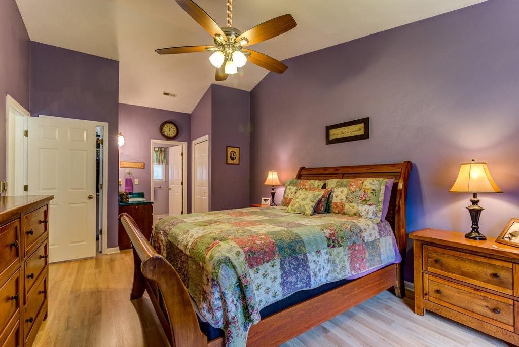 121 Oak Ridge Court Blue Ridge, VA 24064 - Photo 23 of 63 a bedroom with a bed and a chandelier