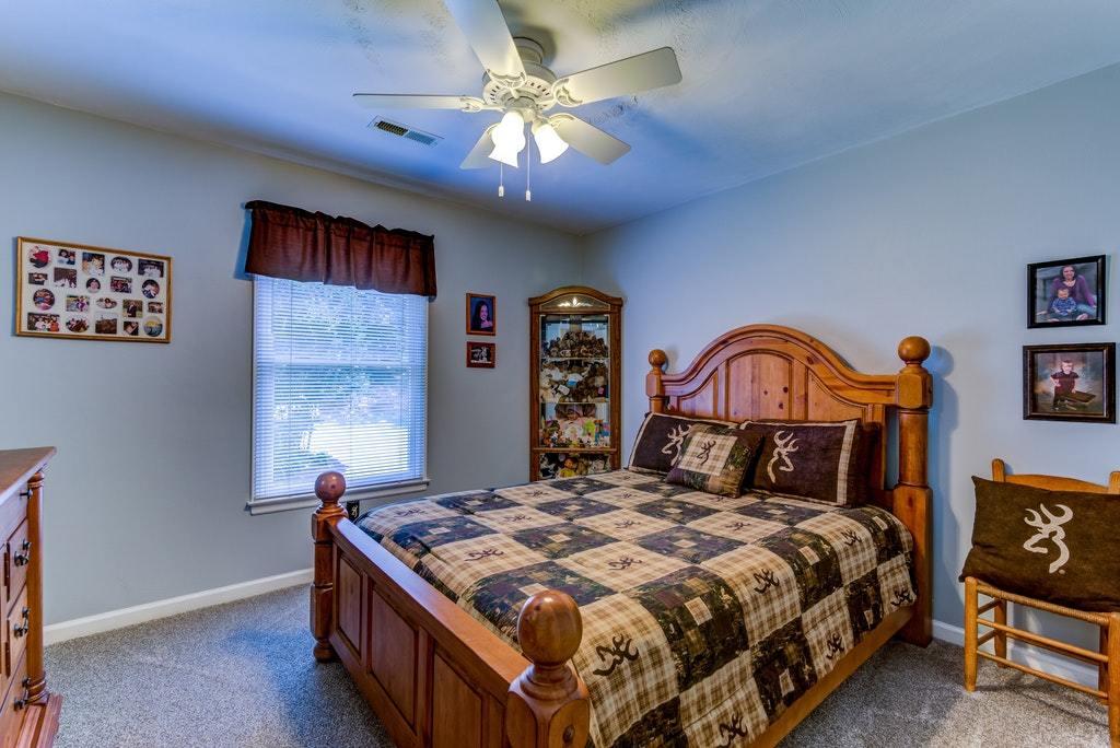121 Oak Ridge Court Blue Ridge, VA 24064 - Photo 30 of 63 a bedroom with a bed and a chandelier