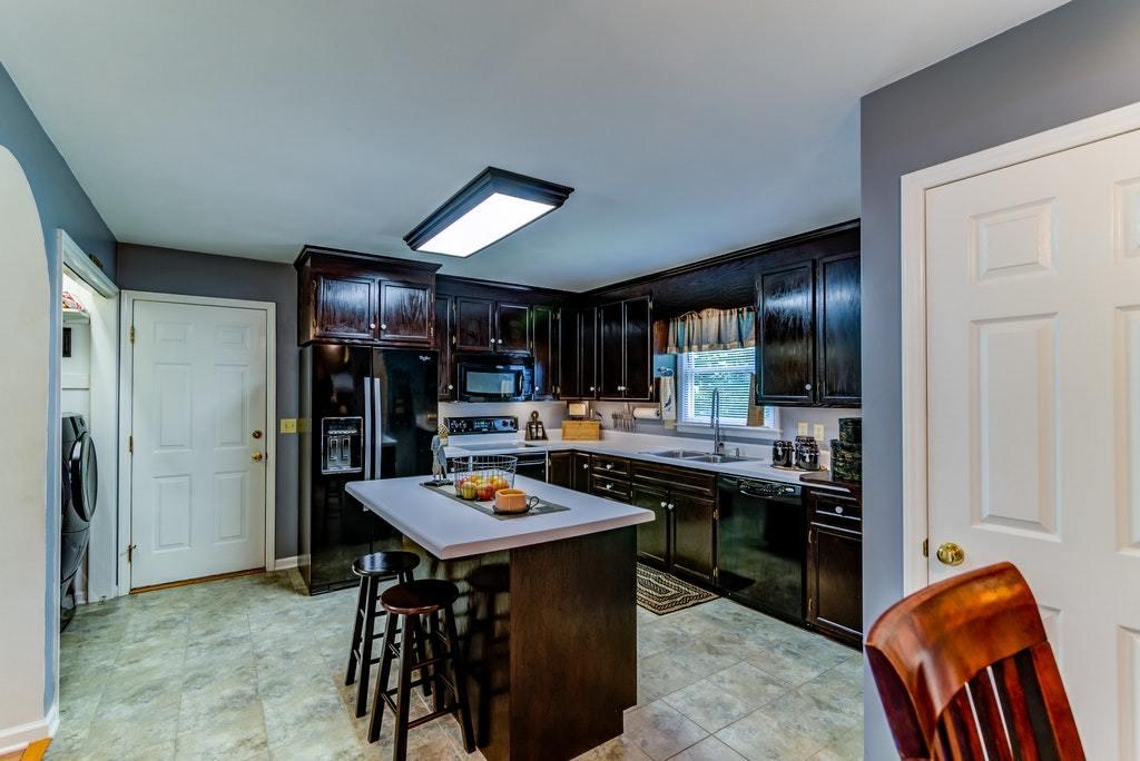 121 Oak Ridge Court Blue Ridge, VA 24064 - Photo 10 of 63 a kitchen with stainless steel appliances kitchen island granite countertop a table and chairs in it