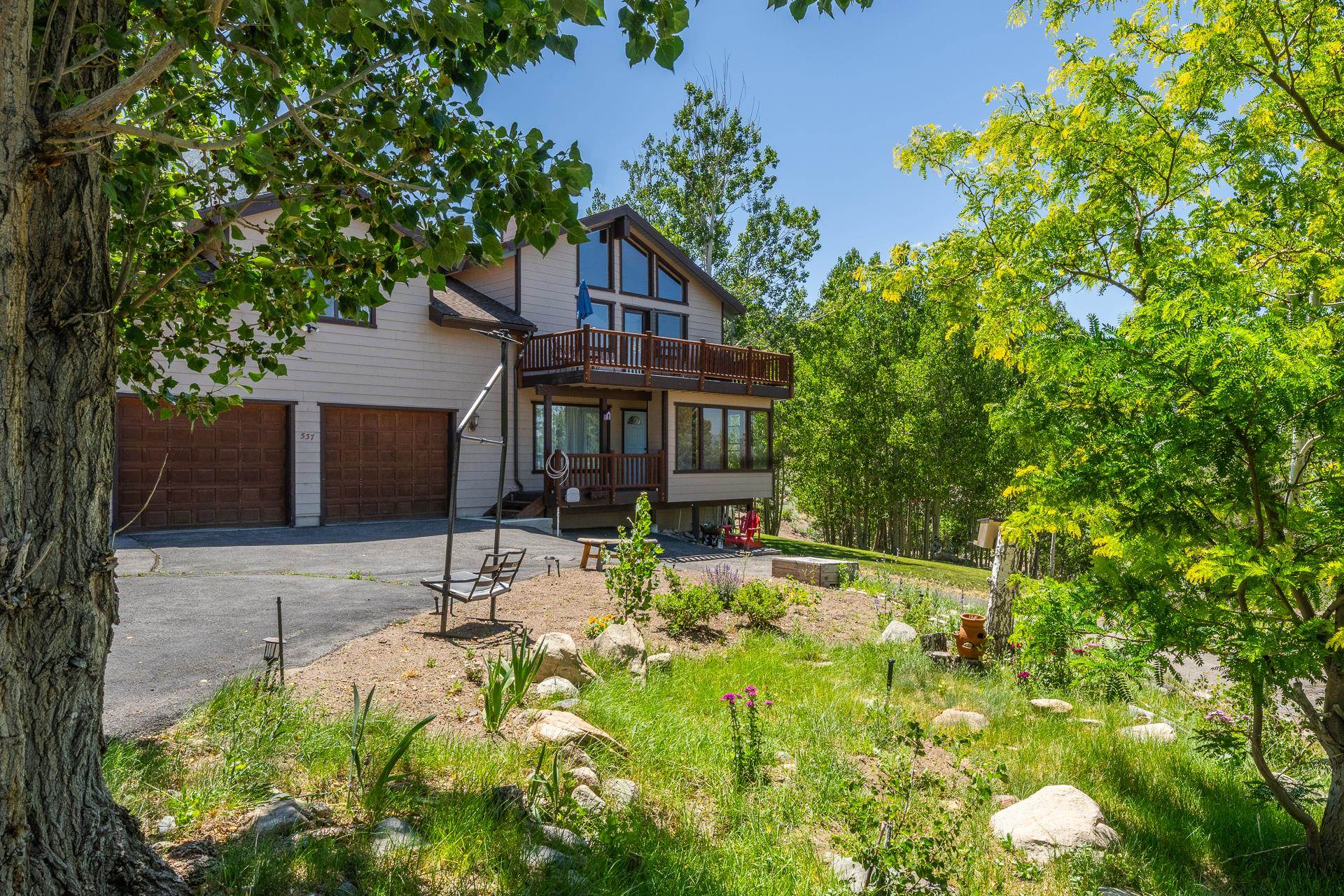 537 Aspen Spring Ranch Road Mammoth Lakes, CA 93546 - Photo 2 of 40 Contemporary exterior featuring a two-car garage with wood-finish doors, a full-width upper deck, and expansive windows