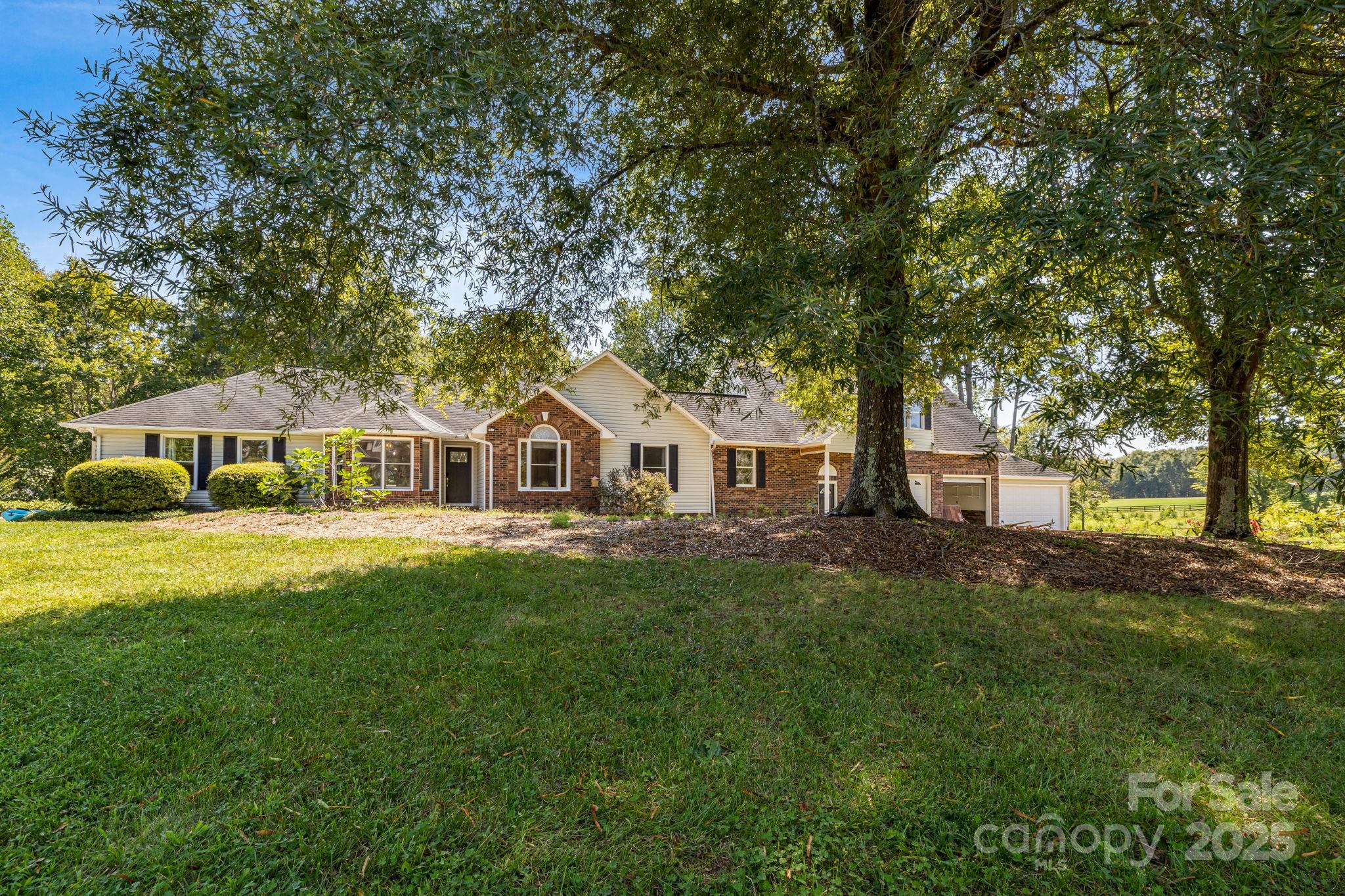 a front view of a house with yard and green space