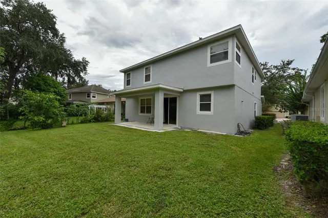 a front view of a house with a yard and potted plants