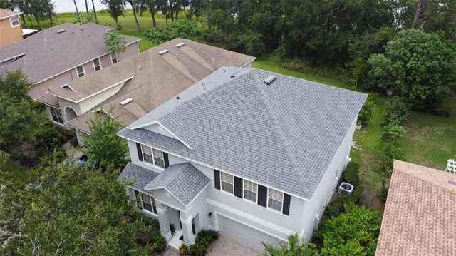an aerial view of a house with garden space and lake view