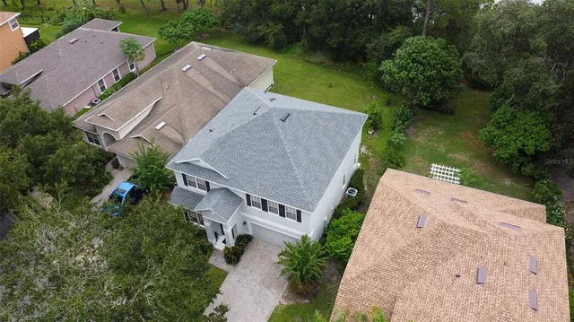 an aerial view of a house with a yard swimming pool and lake view