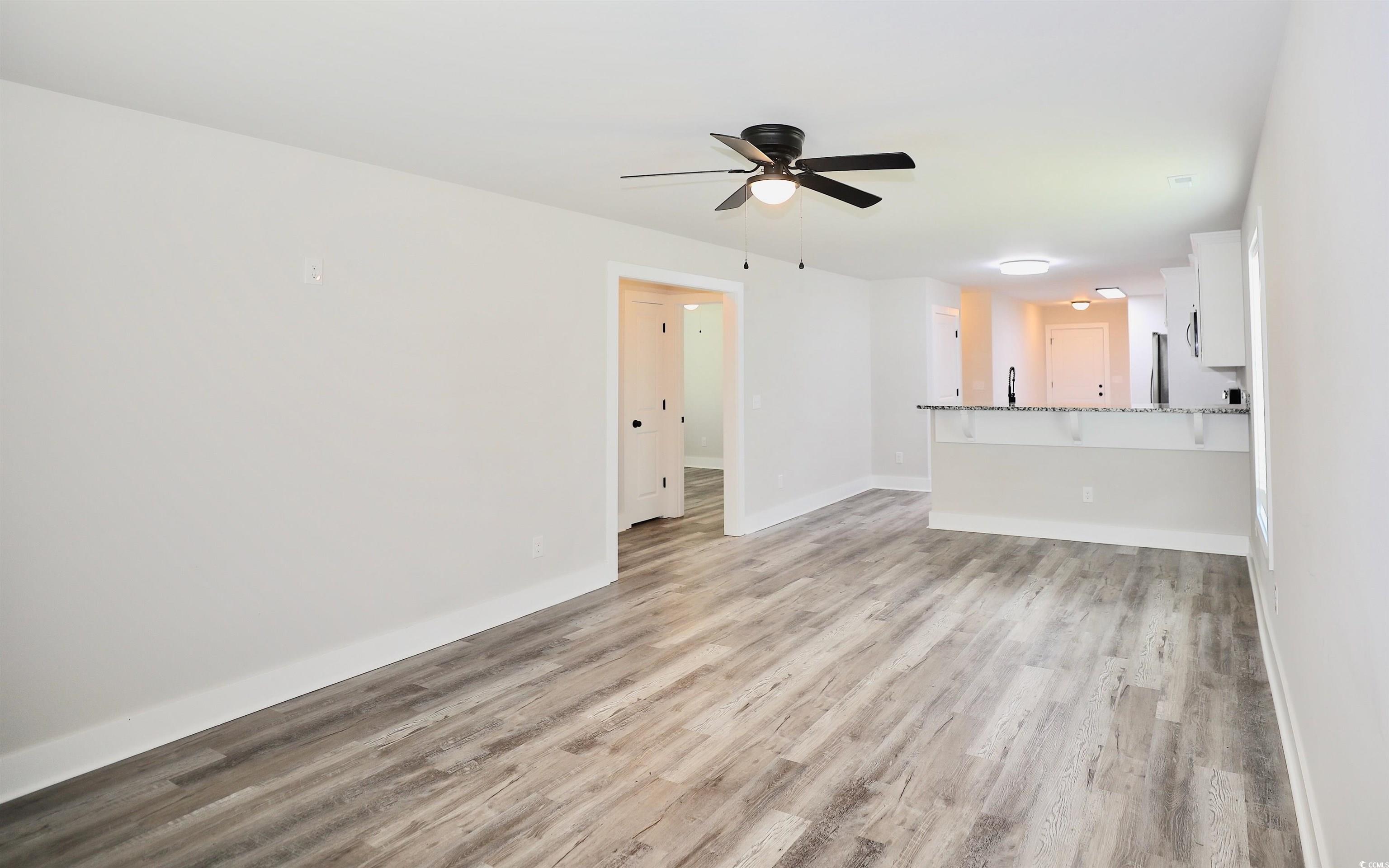 3216 South Hill Road Timmonsville, SC 29161 - Photo 2 of 19 Unfurnished living room featuring light wood-style flooring and a ceiling fan