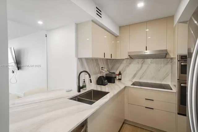 a kitchen with a sink a refrigerator and cabinets