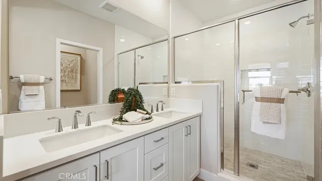 a en suite bathroom with a double vanity sink and a large mirror