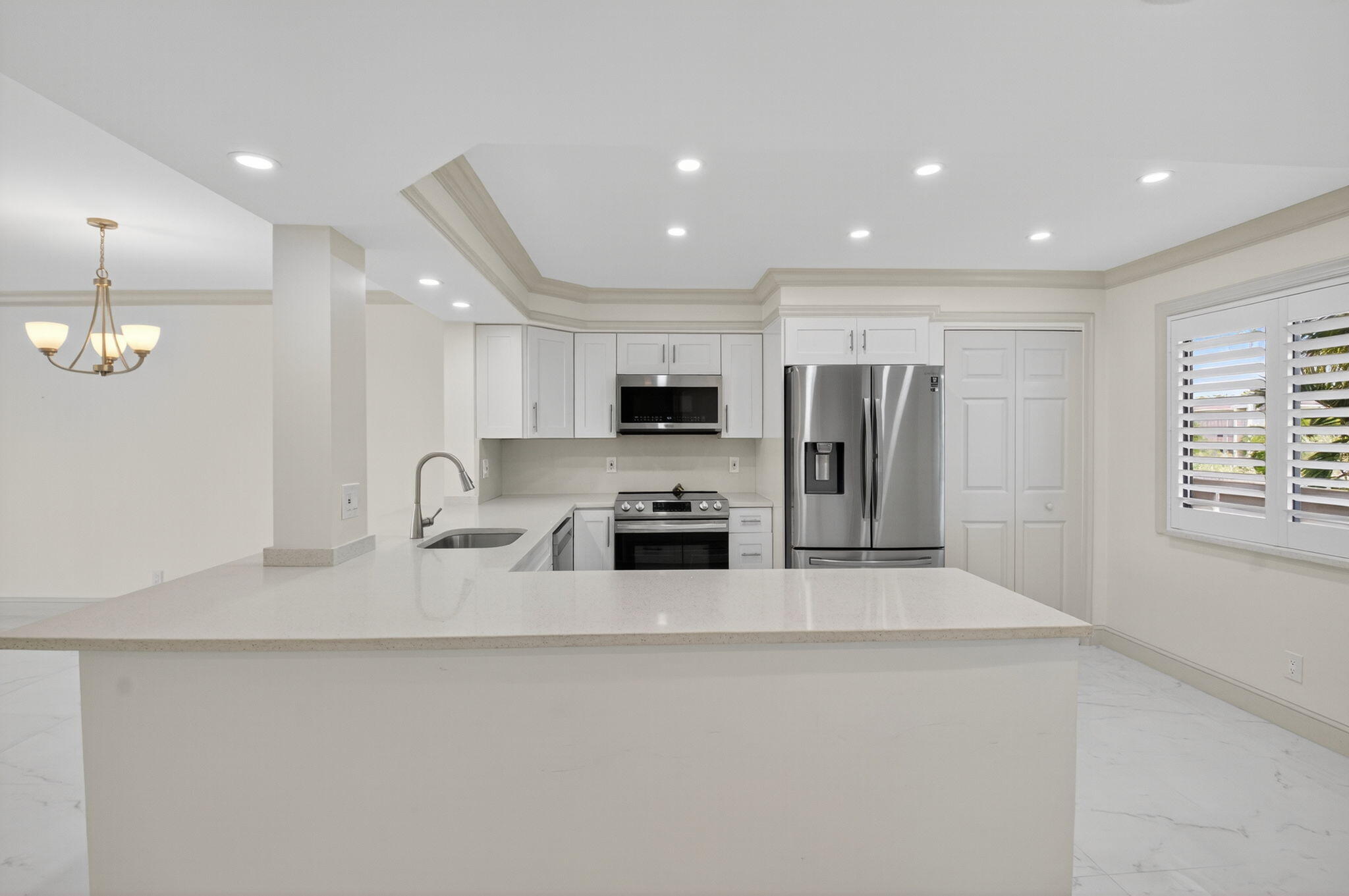 14375 Strathmore Lane, Unit 305 Delray Beach, FL 33446 - Photo 10 of 92 a large kitchen with stainless steel appliances a large counter top a stove and a refrigerator