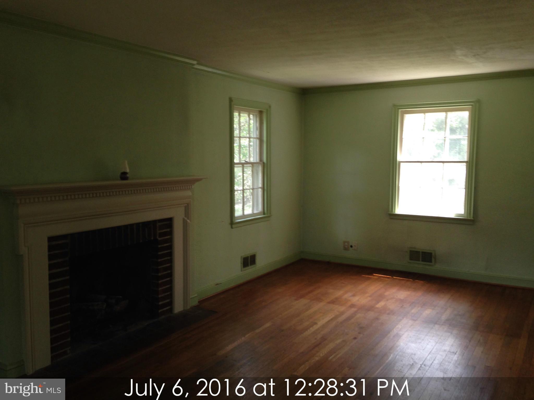 3715 Buckingham Road Baltimore, MD 21207 - Photo 3 of 9 a view of an empty room with wooden floor and a window