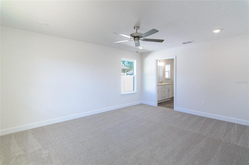 2 Seckel Court Palm Coast, FL 32164 - Photo 14 of 26 an empty room with chandelier fan and windows