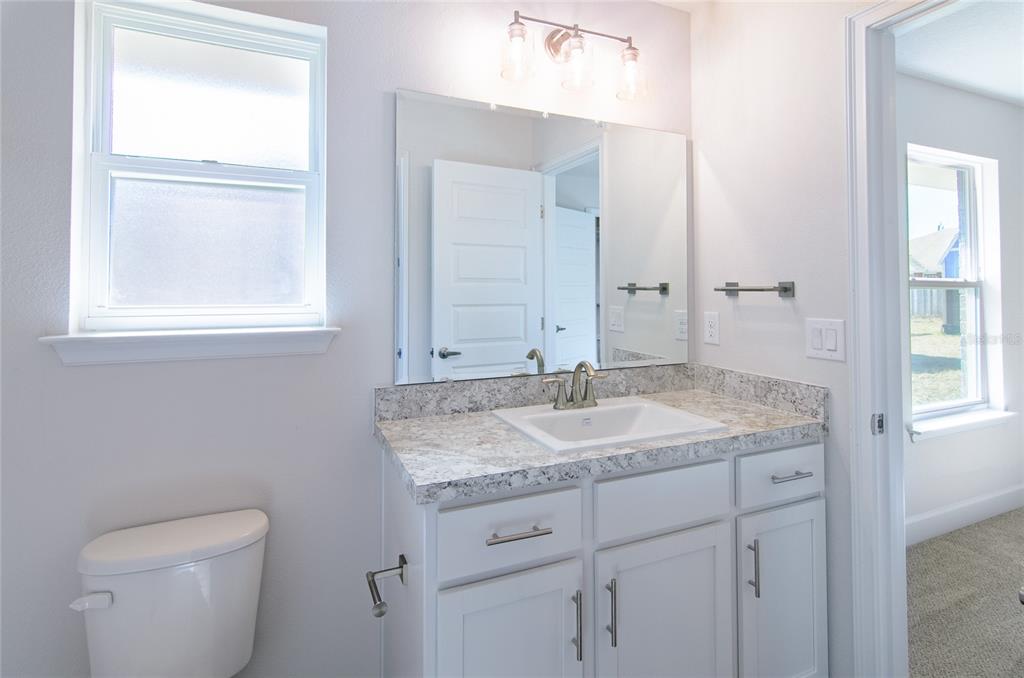 2 Seckel Court Palm Coast, FL 32164 - Photo 21 of 26 a bathroom with a granite countertop sink toilet and mirror