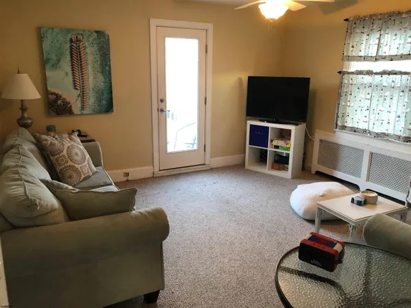 a living room with furniture a window and a flat screen tv
