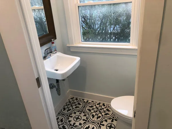 a bathroom with a sink toilet and window