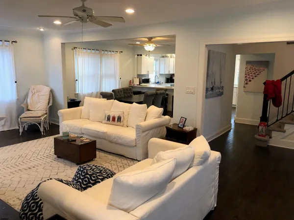 a living room with furniture a rug and a mirror