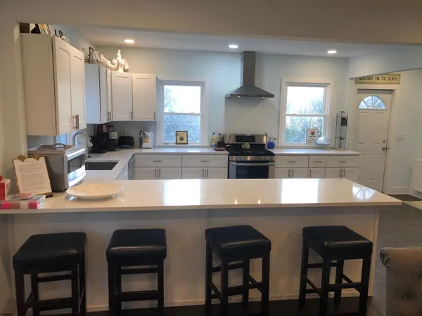 a kitchen with a dining table chairs and refrigerator