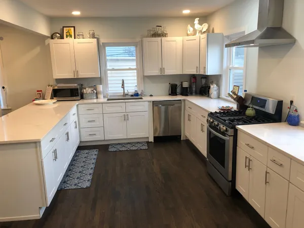 a kitchen with granite countertop a sink stove and cabinets