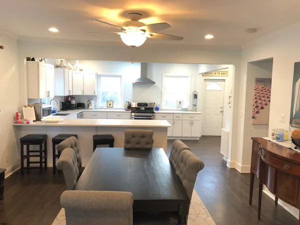 a open kitchen with stainless steel appliances granite countertop a stove a sink a dining table and chairs