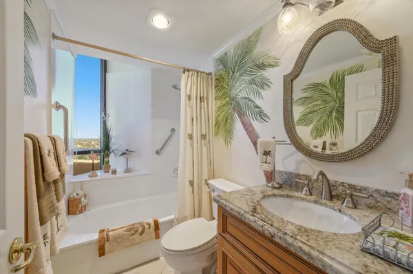 a bathroom with a granite countertop toilet a sink and a mirror