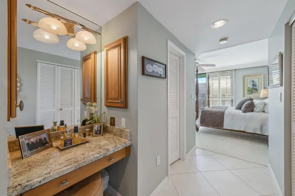 a en suite bathroom with a granite countertop sink and a mirror