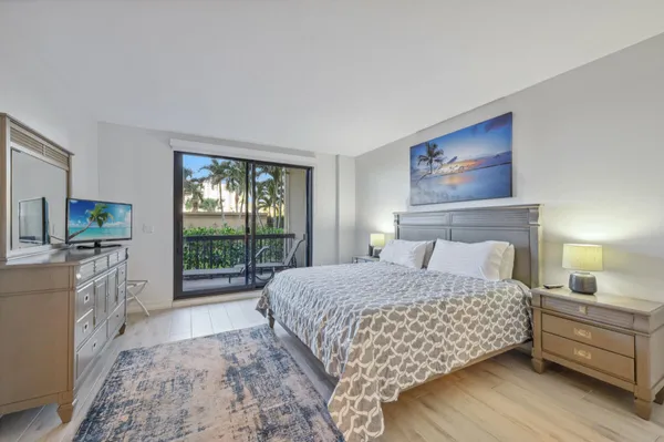a bedroom with a large bed and a flat tv screen
