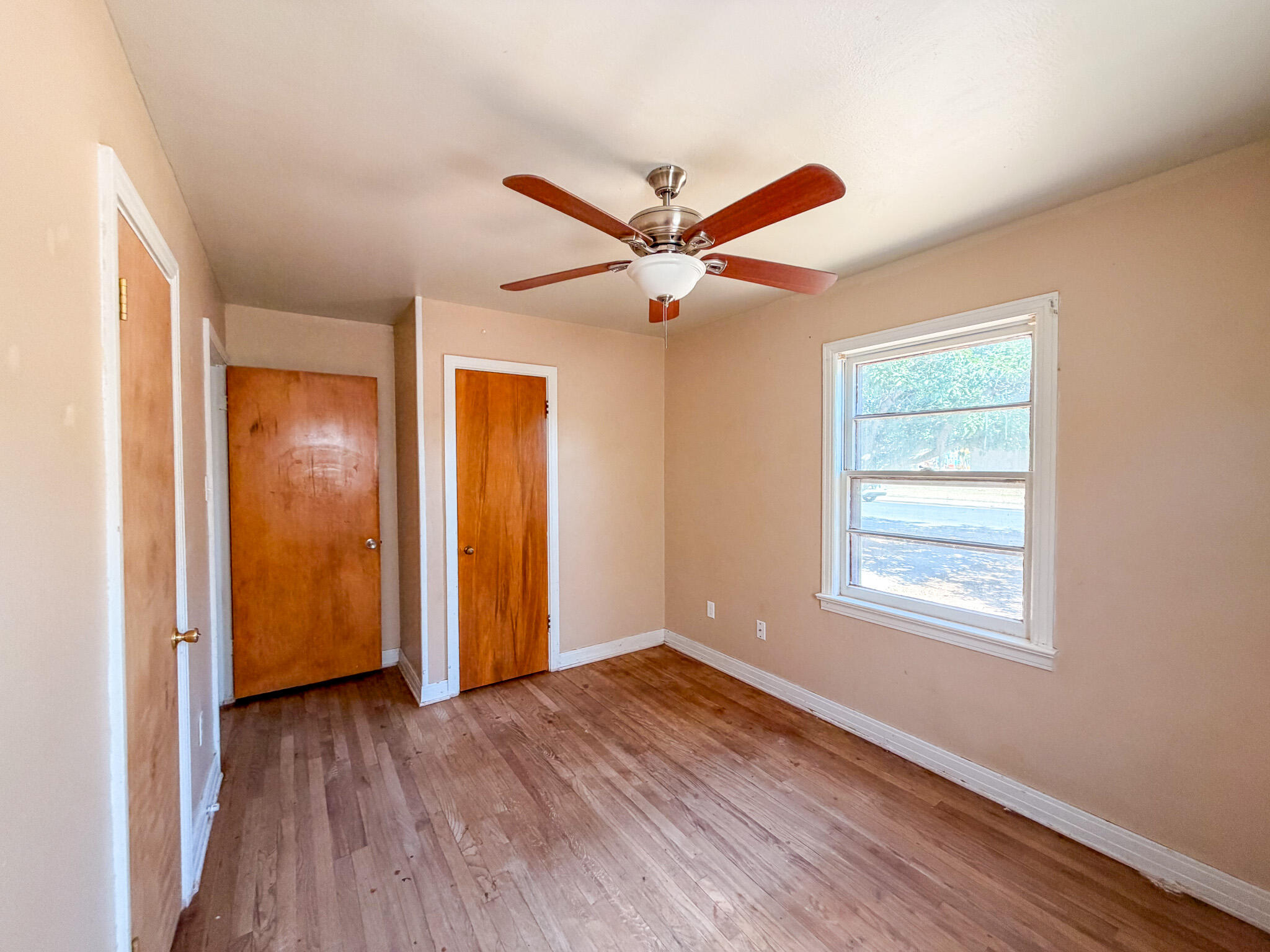 3207 Amherst Street Lubbock, TX 79415 - Photo 6 of 16 a view of an empty room with wooden floor and a window