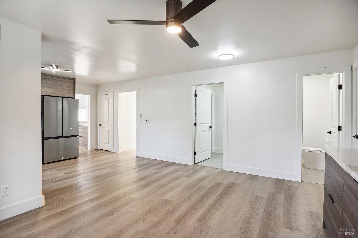1282 Fowler Creek Road Sonoma, CA 95476 - Photo 24 of 86 a view of an empty room with wooden floor and a ceiling fan