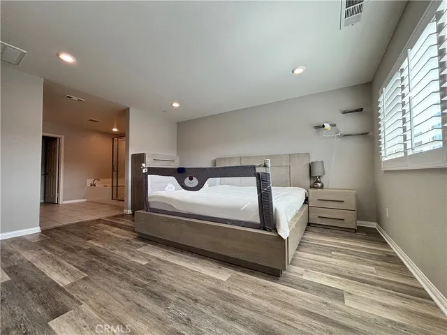 a spacious bedroom with a bed and a window