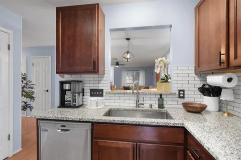 a kitchen with granite countertop a sink and a white cabinets