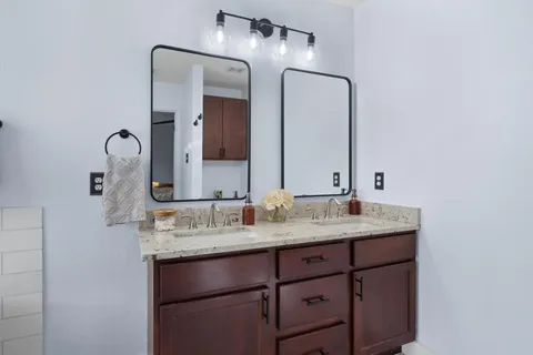 a bathroom with a granite countertop sink vanity and a mirror