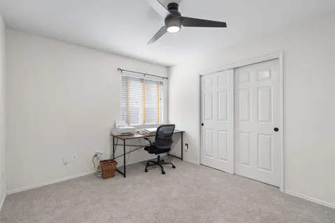 a view of a workspace with furniture and a window