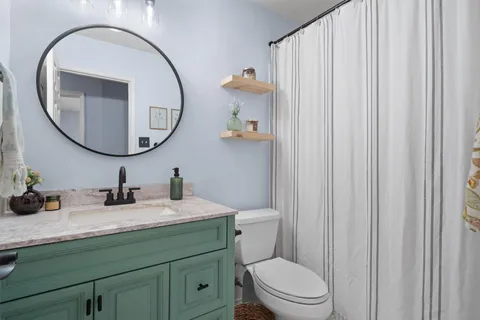a bathroom with a toilet a sink and a mirror