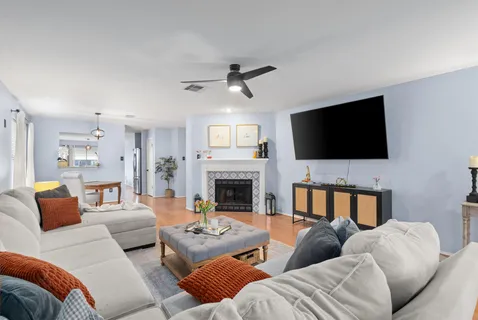 a living room with furniture a flat screen tv and a fireplace