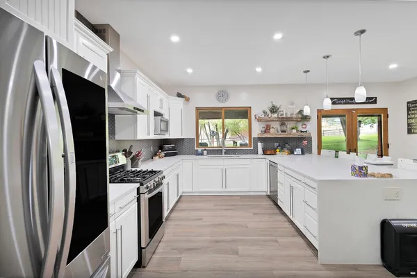 a large kitchen with stainless steel appliances sink a microwave and cabinets