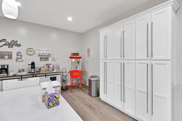 a view of a kitchen with white cabinets and wooden floor