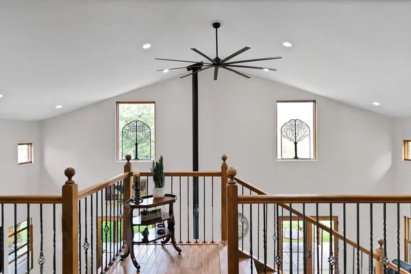a view of a hallway with wooden floor and stairs
