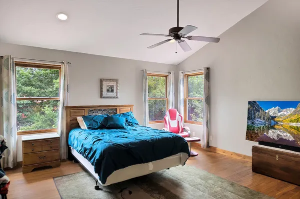 a bedroom with a bed and wooden floor