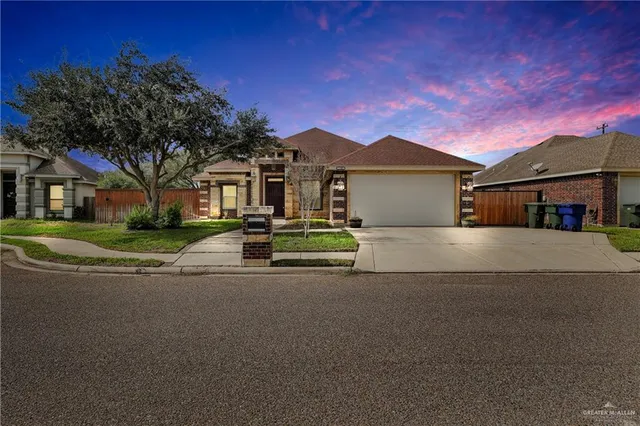a front view of a house with a garden and trees