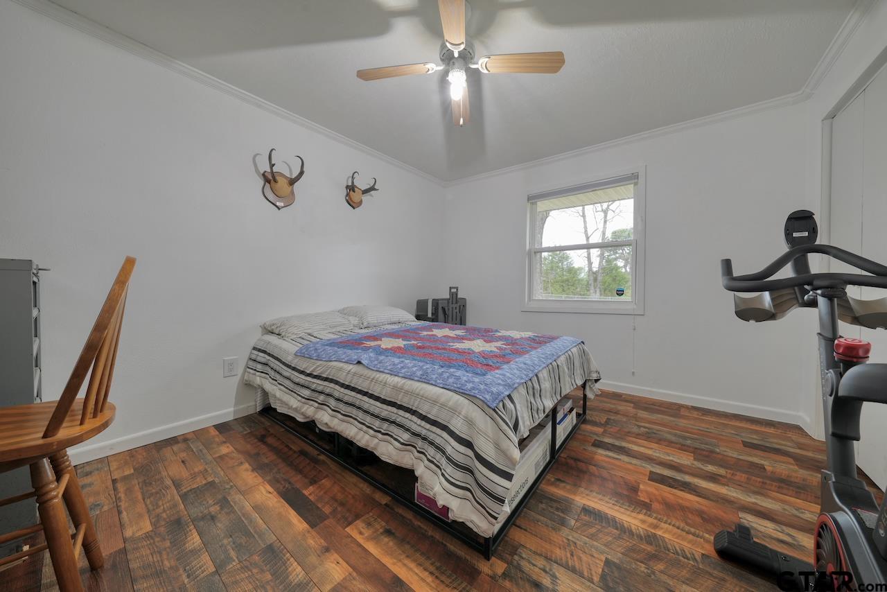667 Allen Road Longview, TX 75605 - Photo 23 of 48 a bedroom with a bed and a chandelier