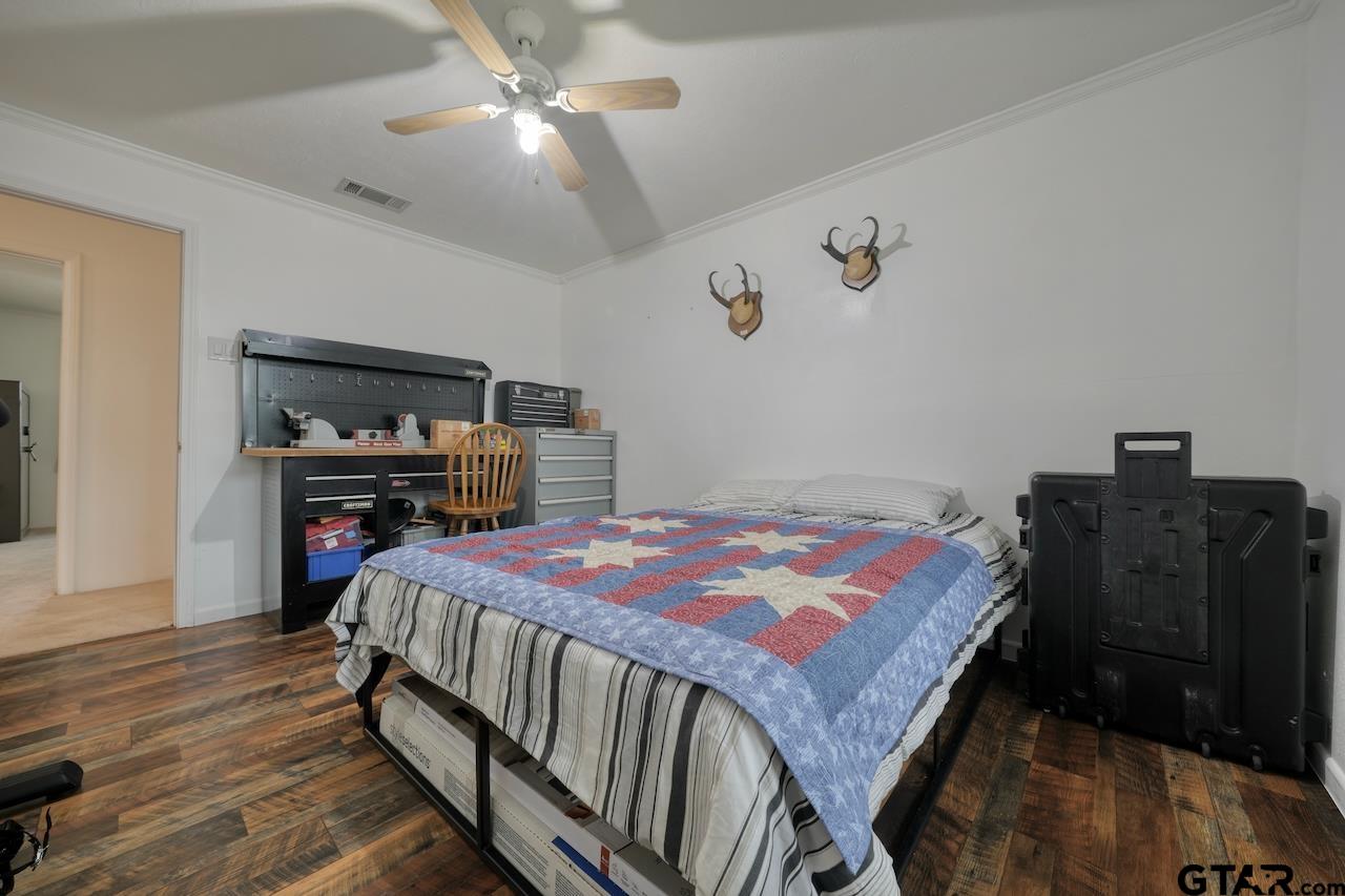 667 Allen Road Longview, TX 75605 - Photo 24 of 48 a bedroom with a bed and wooden floor