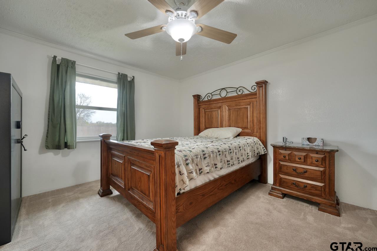 667 Allen Road Longview, TX 75605 - Photo 25 of 48 a bedroom with a bed and a chandelier fan