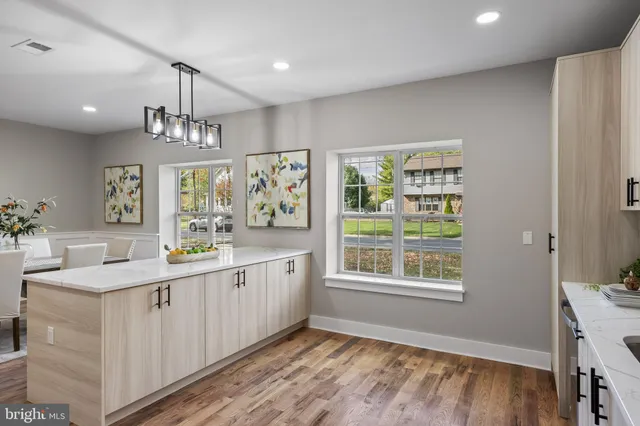 a kitchen with granite countertop a sink cabinets window and wooden floor