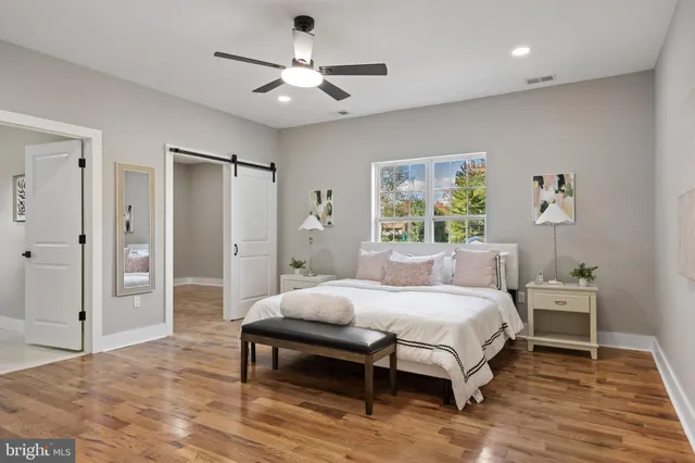 a bedroom with a bed a chandelier and a dresser