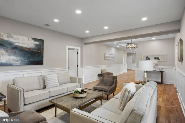a living room with furniture and a glass table with wooden floor