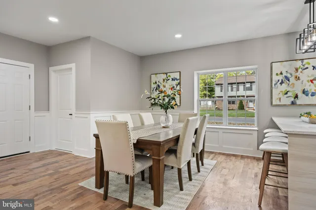 a view of a dining room with furniture a rug and wooden floor