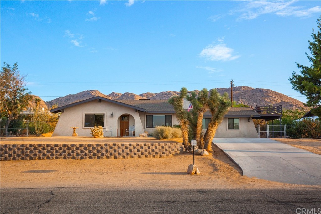 60467 Natoma Trail Joshua Tree, CA 92252 - Photo 1 of 63 a front view of a house with garden