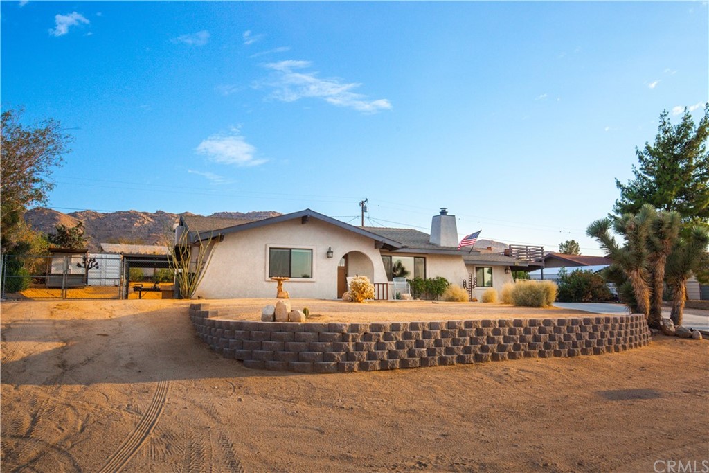 60467 Natoma Trail Joshua Tree, CA 92252 - Photo 2 of 63 a front view of a house with a yard and garage